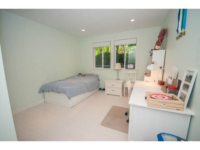 Bright bedroom with white walls, desk, and windows, showcasing a serene view. - 389 Beachview Dr, North Vancouver
