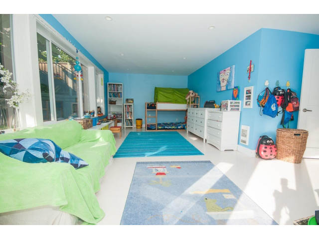 Bright and colorful kids' bedroom with green bedding, blue walls, and a play area. - 389 Beachview Dr, North Vancouver