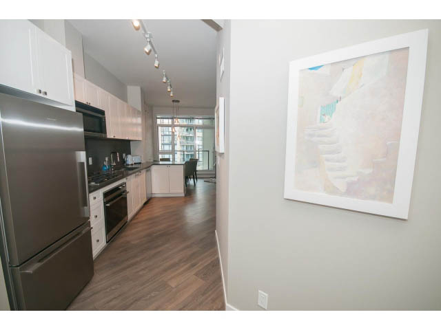 Bright kitchen with stainless steel appliances, hardwood floors, and a city view. - 405 - 105 West 2nd St, North Vancouver