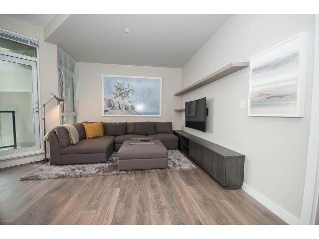 Furnished living room with hardwood floors and a city view. - 405 - 105 West 2nd St, North Vancouver