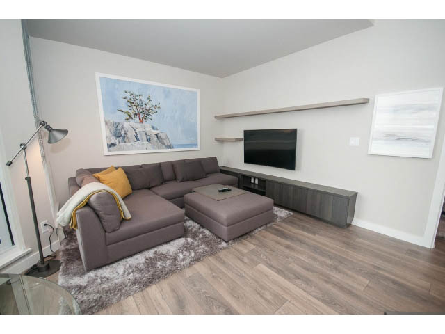Furnished living room with hardwood floors and modern decor. - 405 - 105 West 2nd St, North Vancouver
