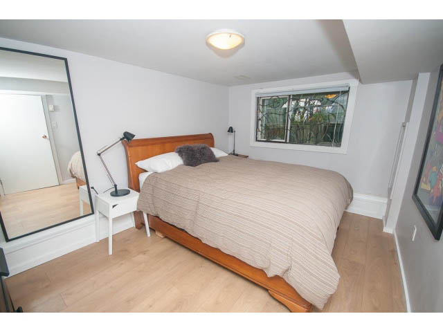 Furnished 1-bedroom suite with hardwood floors and a cozy bed setup. - Suite - 817 Union St, Vancouver East Side