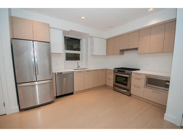 Bright kitchen with stainless steel appliances, light wood cabinets, and hardwood floors. - 9 - 3508 Mount Seymour Pkwy, North Vancouver