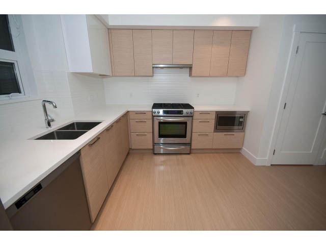Bright kitchen with white countertops, light wood cabinets, and hardwood floors. - 9 - 3508 Mount Seymour Pkwy, North Vancouver