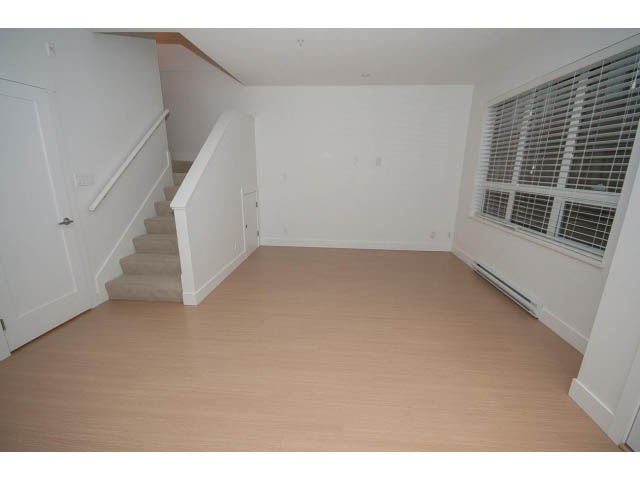 Bright living room with hardwood floors and a staircase leading to upper level. - 9 - 3508 Mount Seymour Pkwy, North Vancouver