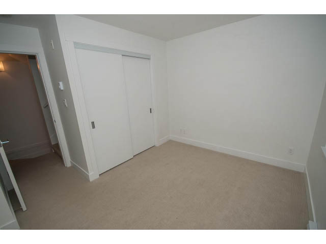 Bright bedroom with sliding closet doors and beige carpet. - 9 - 3508 Mount Seymour Pkwy, North Vancouver