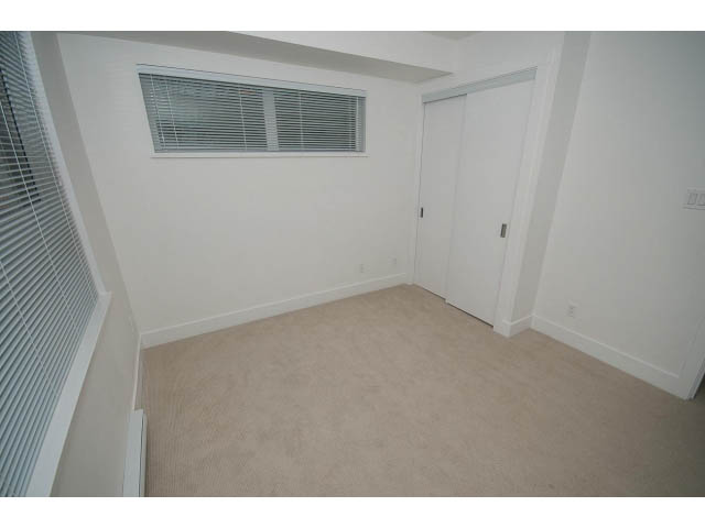 Bright living room with carpeted floor and white walls, featuring a sliding door and a window with blinds.