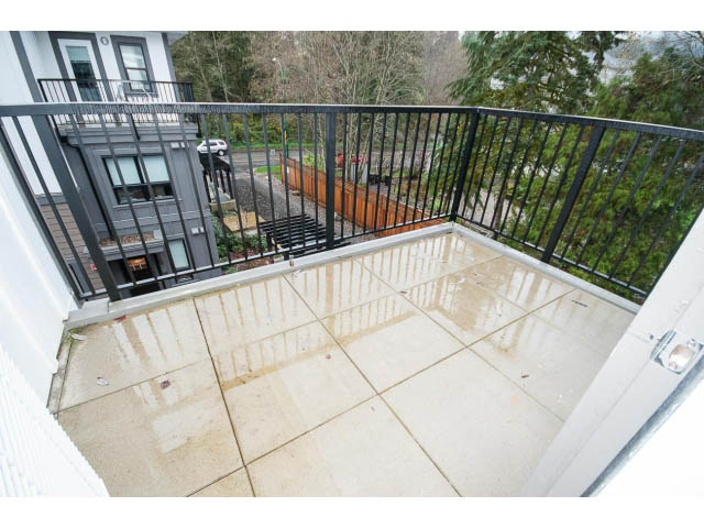 Bright balcony with tiled flooring and black railings, overlooking greenery. - 9 - 3508 Mount Seymour Pkwy, North Vancouver