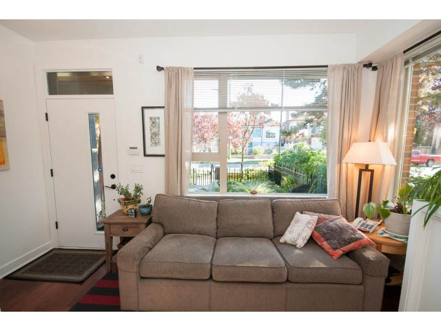 Bright living room with large windows, hardwood floors, and a cozy sofa. - 4539 Prince Albert Street, Vancouver East Side
