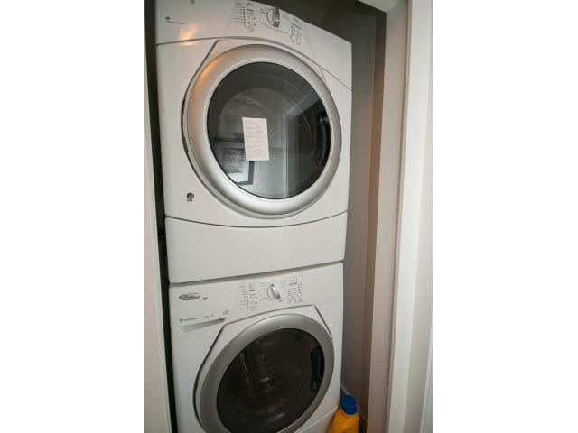 Bright laundry room with stacked washer and dryer, clean and organized. - 4539 Prince Albert Street, Vancouver East Side