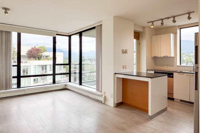 Open-concept living space with mountain views through floor-to-ceiling windows and modern kitchen island.