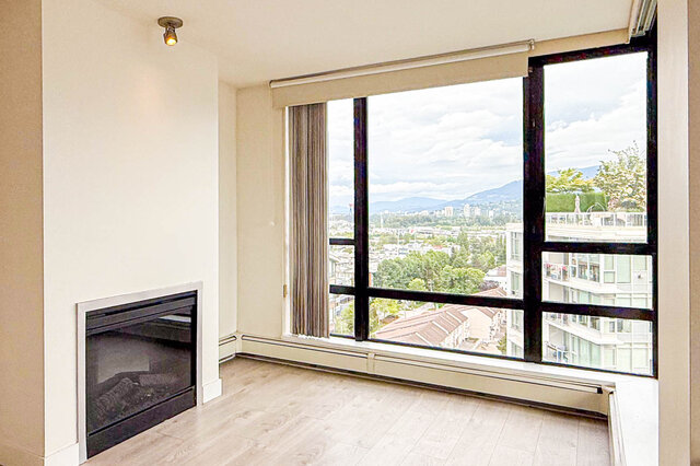 Bright living room with city view through large windows and modern fireplace. - 1605 - 151 West 2nd Street, North Vancouver