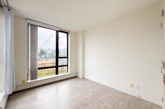 Bright living space with large windows showcasing city views and light hardwood flooring. - 1605 - 151 West 2nd Street, North Vancouver