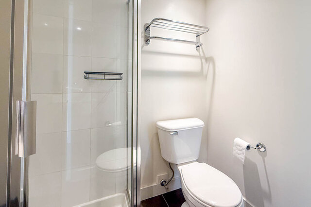 Bright bathroom with glass shower enclosure and chrome towel rack. - 1605 - 151 West 2nd Street, North Vancouver