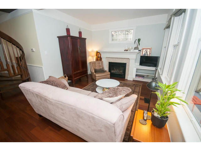 Furnished living room with hardwood floors, fireplace, and cozy seating. - Upper - 817 Union St, Vancouver East Side