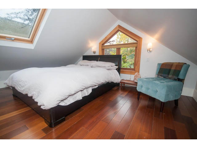 Attic bedroom with hardwood floors and a window view. - Upper - 817 Union St, Vancouver East Side