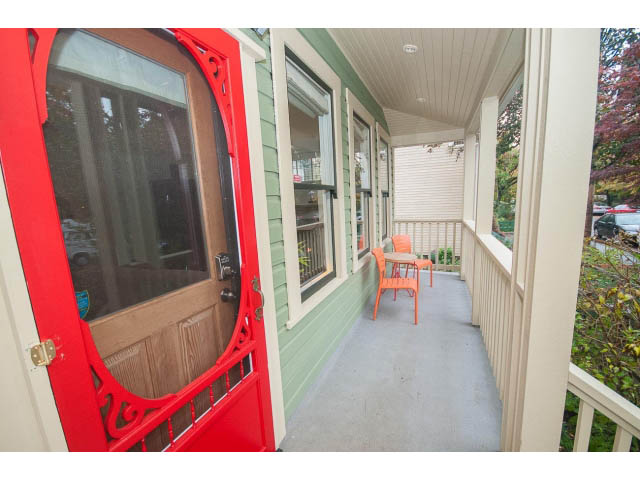 Furnished porch with red door and green siding, leading to a shared house. - Upper - 817 Union St, Vancouver East Side