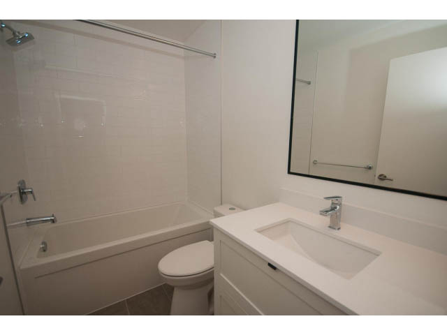 Bright bathroom with white countertop and modern fixtures. - 410 - 3205 Mountain Hwy, North Vancouver