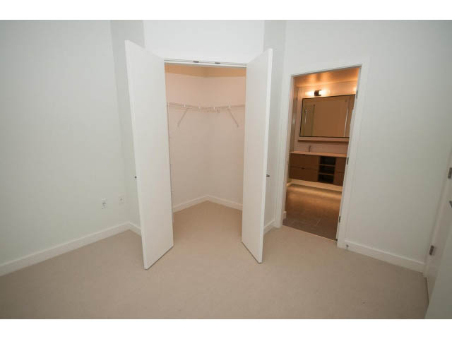Den with open closet and built-in shelving, neutral tones. - 410 - 3205 Mountain Hwy, North Vancouver