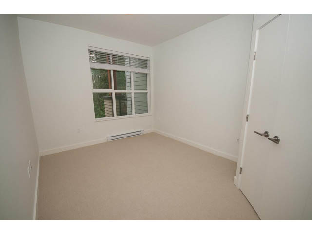 Den with carpeted floor, small window, and door leading to another room. - 410 - 3205 Mountain Hwy, North Vancouver