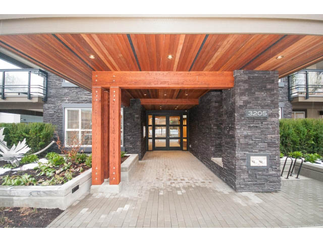 Furnished entryway with stone pillars and wooden ceiling. - 410 - 3205 Mountain Hwy, North Vancouver