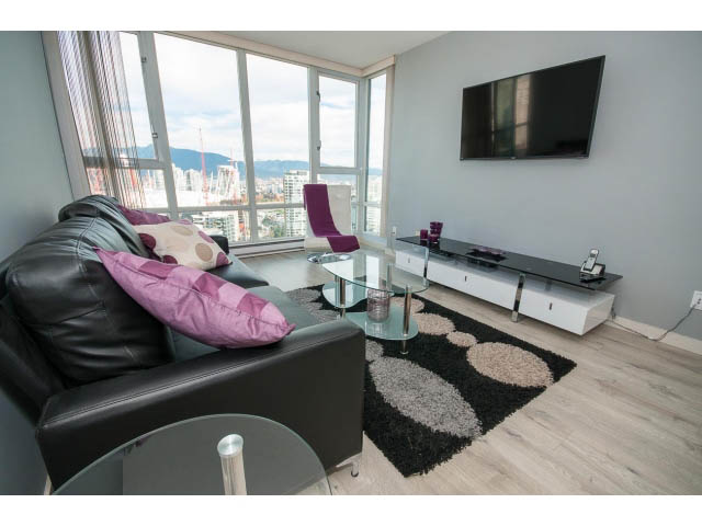 Spacious living room with hardwood floors, city view, and modern furnishings. - 3602 - 1033 Marinaside Crescent, Vancouver Downtown