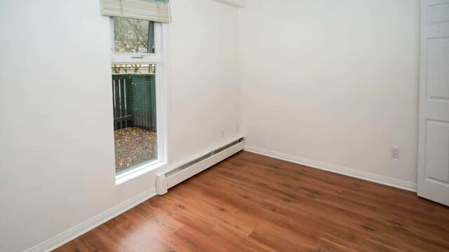 Bright bedroom with hardwood floors, white walls, and a window. - 13-870 West 7th Avenue, Vancouver West Side
