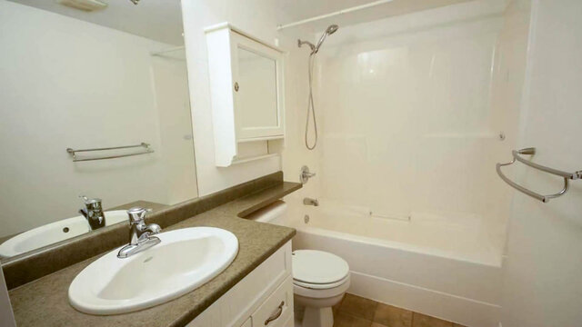 Bathroom with a granite countertop vanity, oval sink, and a white tub-shower combo. - 13-870 West 7th Avenue, Vancouver West Side