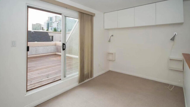Bright den with sliding glass door to a wooden deck and white wall cabinets. - 13-870 West 7th Avenue, Vancouver West Side