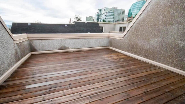 Spacious rooftop deck featuring weathered wooden plank flooring and a view of the city skyline. - 13-870 West 7th Avenue, Vancouver West Side