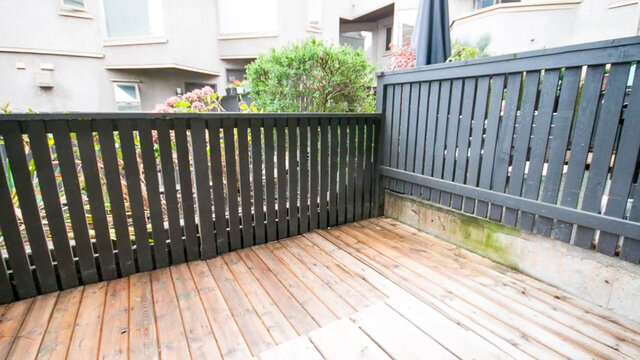 Cozy wooden deck with light plank flooring and dark vertical slat railings. - 13-870 West 7th Avenue, Vancouver West Side