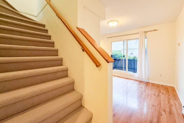 Carpeted stairs with a wood handrail beside the dining area and its sliding glass door to the deck. - 13-870 West 7th Avenue, Vancouver West Side