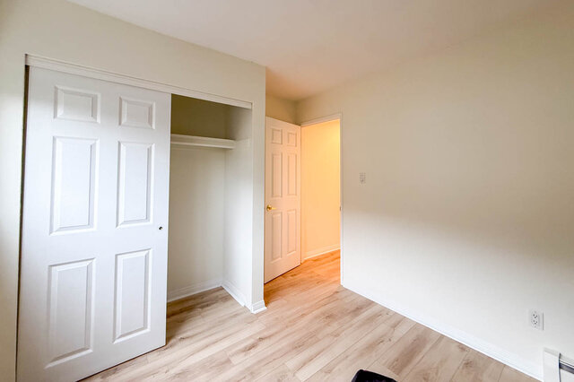 Upper bedroom with a sliding-door closet with shelf and rod, hardwood floors and baseboard heating. - 13-870 West 7th Avenue, Vancouver West Side