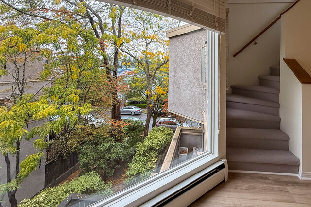 Close view from the living room picture window over golden autumn trees, gardens and the quiet street, stairs to the loft alo