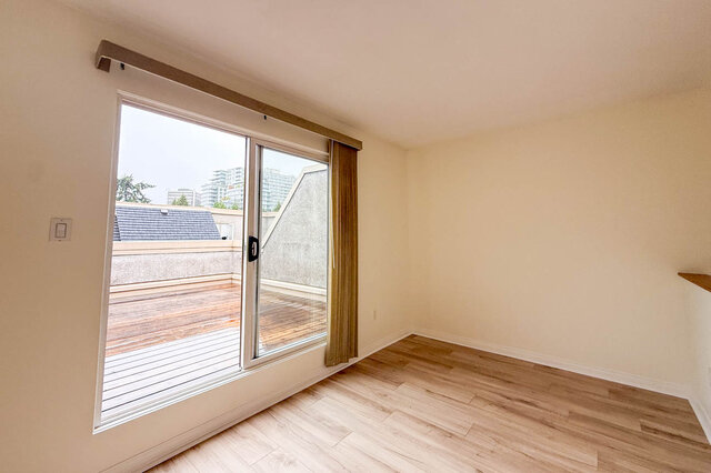 Loft den with a sliding glass door straight onto the private rooftop deck, city towers visible beyond. - 13-870 West 7th Avenue, Vancouver West Side