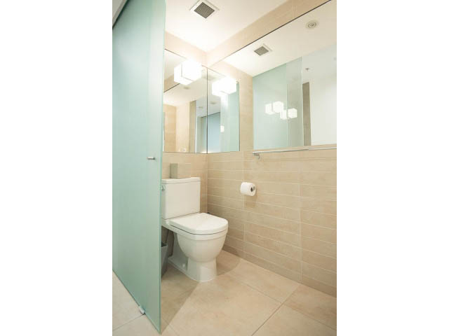 Furnished bathroom with beige tiles and a glass shower door. - 509 - 36 Water Street, Vancouver Downtown