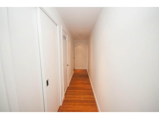 Furnished hallway with wooden floors and white walls. - 4609 - 777 Richards St, Vancouver Downtown
