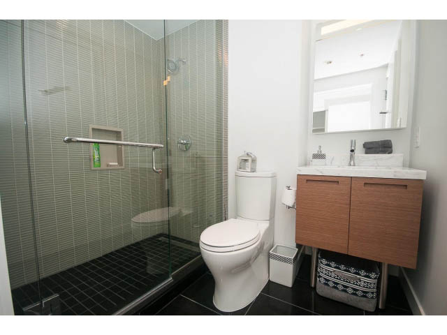 Furnished bathroom with wooden vanity, white sink, and glass shower. - 4609 - 777 Richards St, Vancouver Downtown