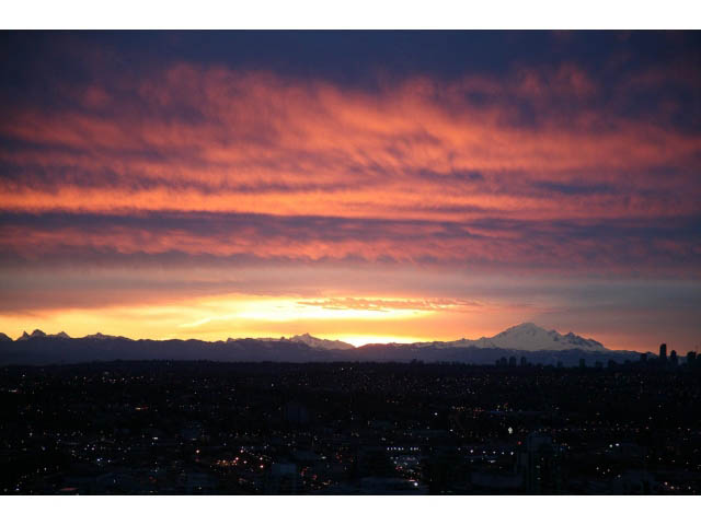 Bright living room with stunning city view and vibrant sunset sky. - 4609 - 777 Richards St, Vancouver Downtown