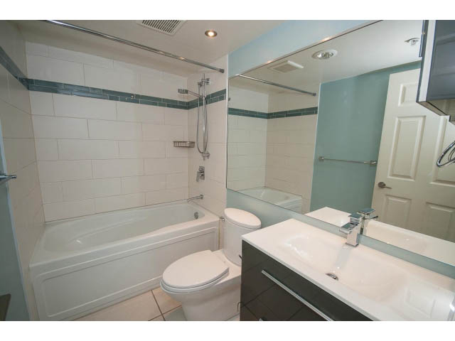 Bright bathroom with white countertop and bathtub, modern fixtures. - 706 - 1088 Quebec St., Vancouver East Side