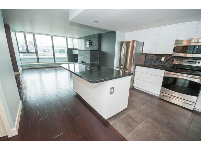 Bright kitchen with modern stainless steel appliances, hardwood floors, and a city view. - 706 - 1088 Quebec St., Vancouver East Side