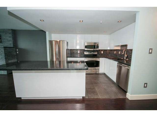 Bright kitchen with white cabinets, granite countertops, stainless steel appliances, and hardwood floors. - 706 - 1088 Quebec St., Vancouver East Side