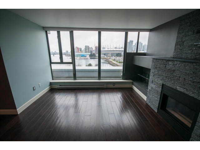 Bright living room with hardwood floors, city view, and modern fireplace. - 706 - 1088 Quebec St., Vancouver East Side
