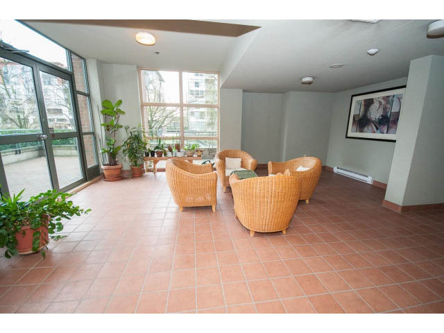 Spacious living room with large windows, tiled floor, and comfortable seating. - 706 - 1088 Quebec St., Vancouver East Side
