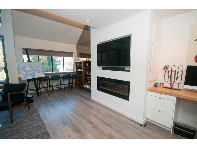 Furnished living room with hardwood floors, city view, and modern decor. - 15 - 2151 Banbury Rd, North Vancouver