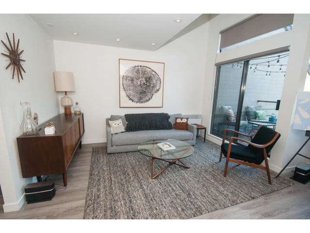 Bright living room with modern furniture, large window, and hardwood floors. - 15 - 2151 Banbury Rd, North Vancouver