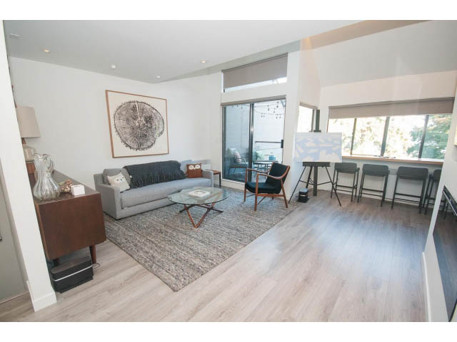 Spacious living room with hardwood floors, modern furniture, and large windows. - 15 - 2151 Banbury Rd, North Vancouver