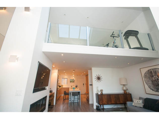 Bright open-concept living space with modern decor, hardwood floors, and a skylight. - 15 - 2151 Banbury Rd, North Vancouver