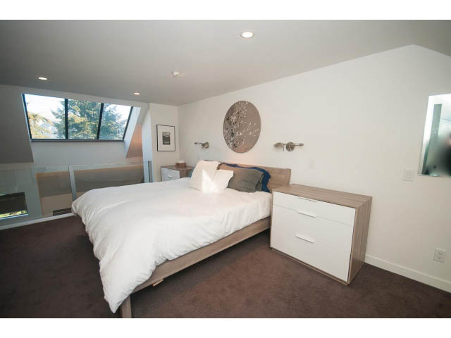 Bright bedroom with modern decor, large windows, and a unique wall design. - 15 - 2151 Banbury Rd, North Vancouver