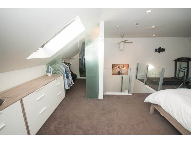 Furnished bedroom with slanted ceiling, mirrored closet, and carpeted floor. - 15 - 2151 Banbury Rd, North Vancouver